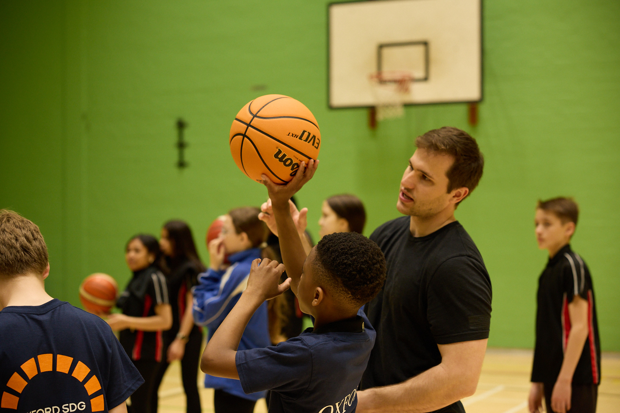 Pupils being instructed in basketball while practicing