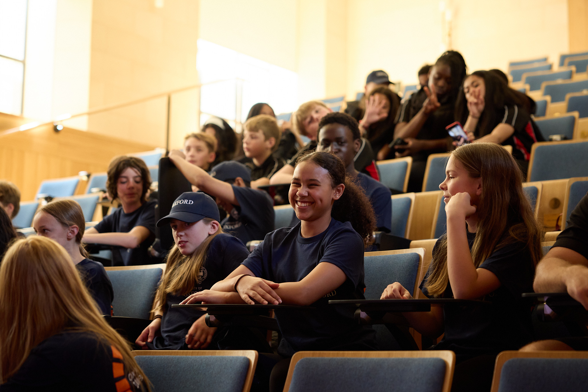 Pupils smiling seated in lecture theatre