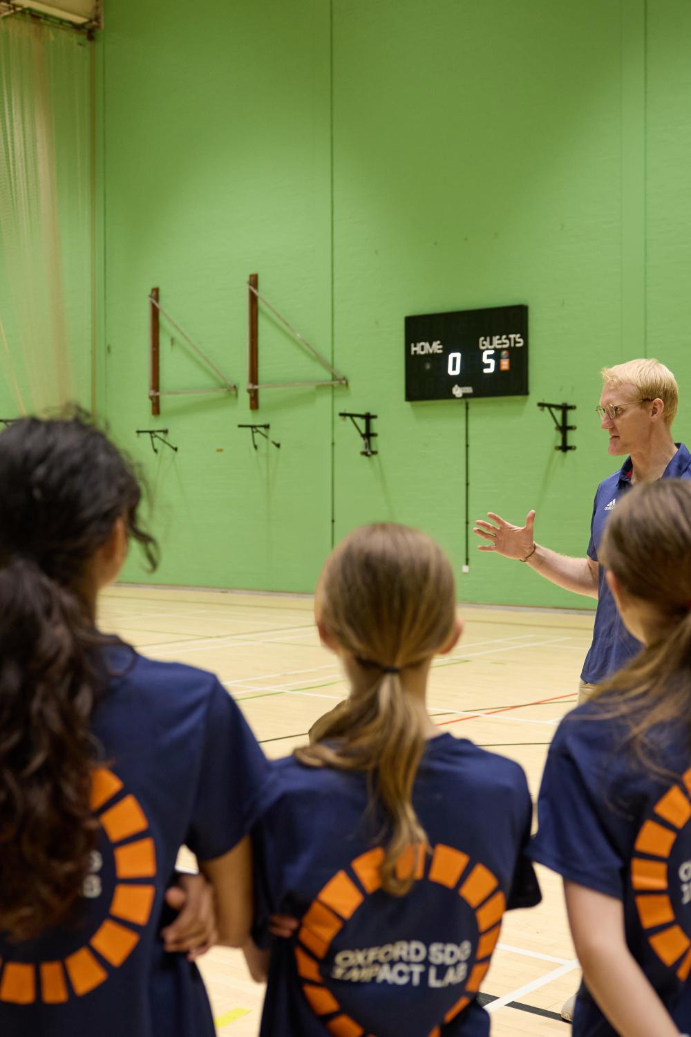 Oliver Cook leading sports exercise to children 