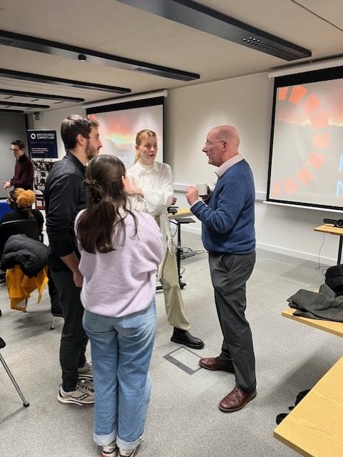 Sir Charles Godfray standing talking to three Fellows