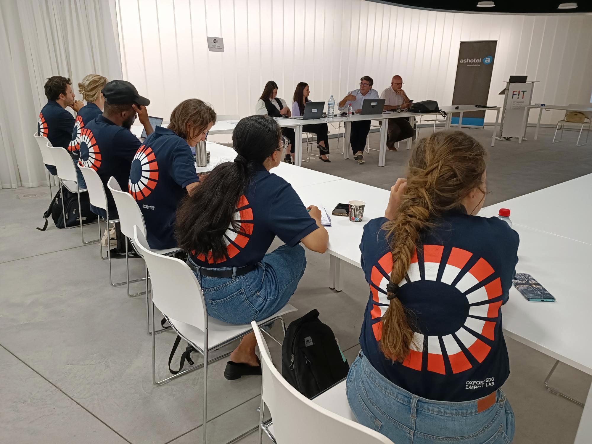 Fellows sitting in a row backs to camera with Lab logo visible