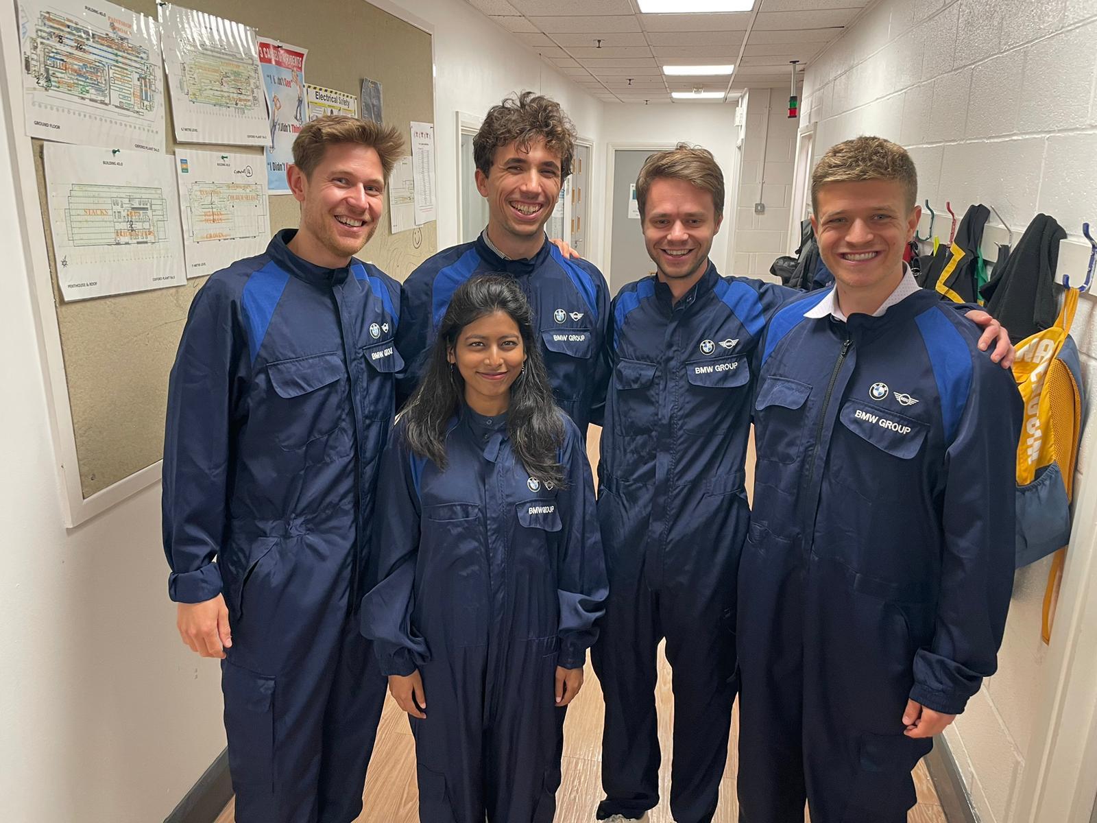 Aurona and Tilmann in a group of fellows wearing BMW boilersuits at plant