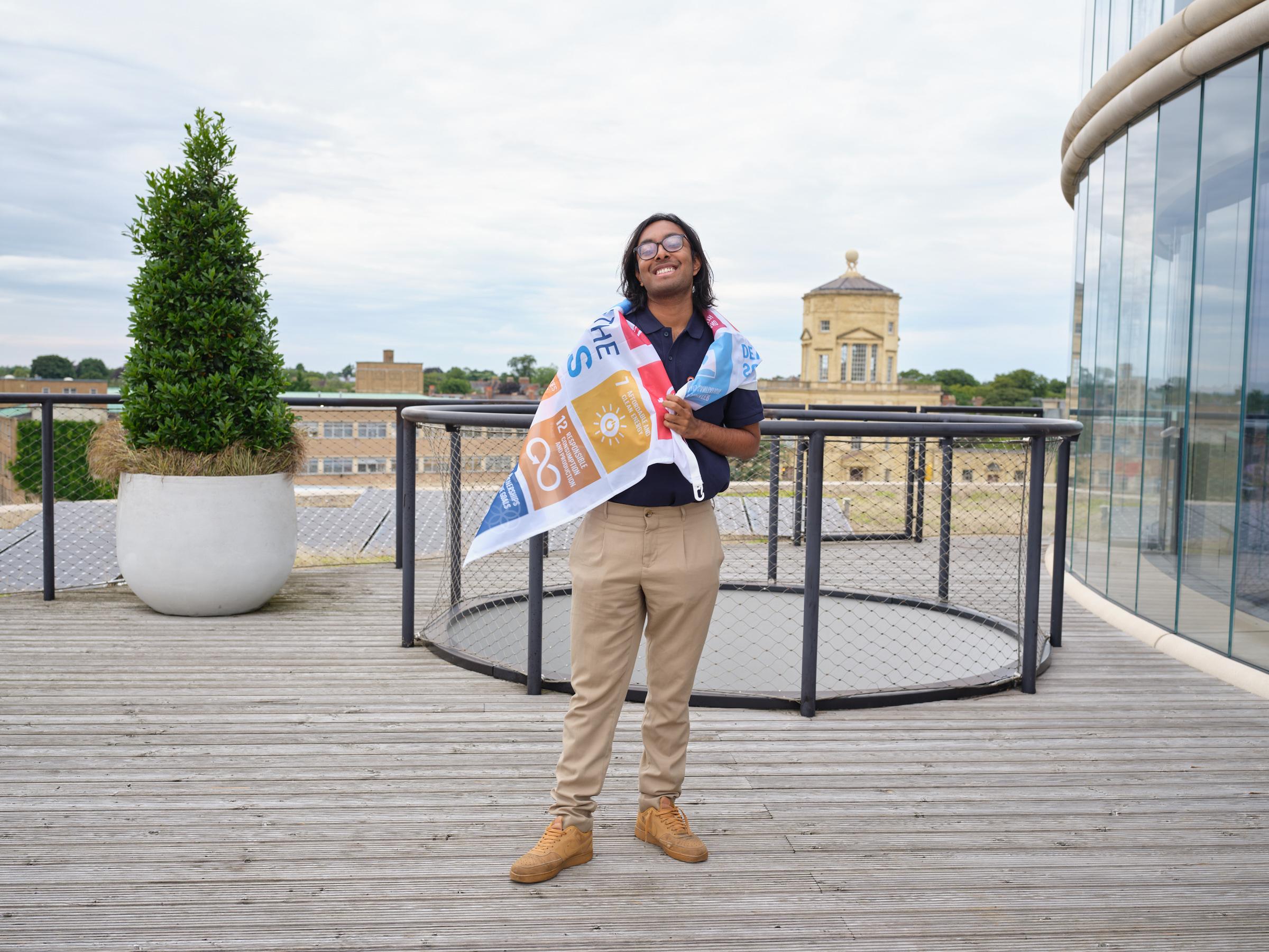 Rafi on the rooftop of the Blavatnik wrapped in an SDG flag